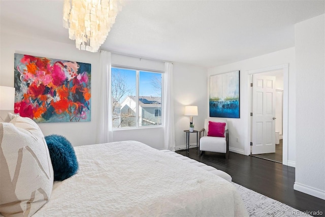 bedroom featuring dark hardwood / wood-style flooring and an inviting chandelier