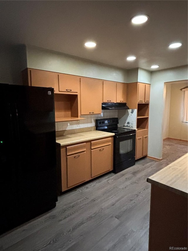 kitchen with black appliances, light hardwood / wood-style floors, backsplash, and light brown cabinetry