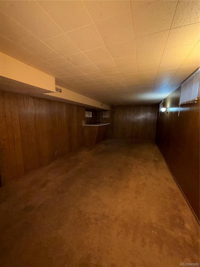 basement with wood walls and carpet floors