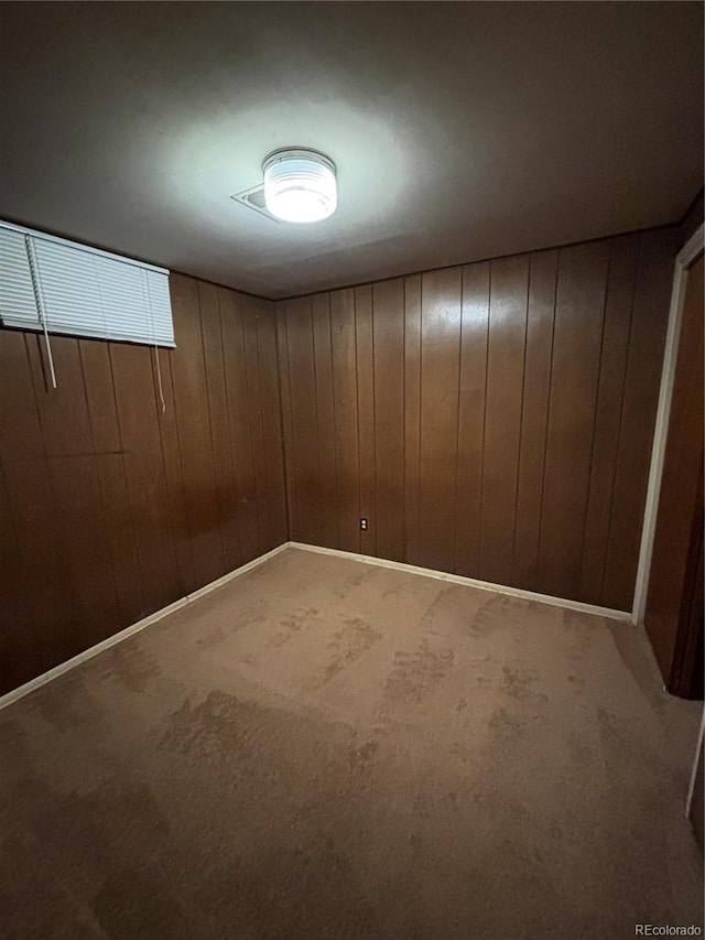 basement featuring carpet and wooden walls