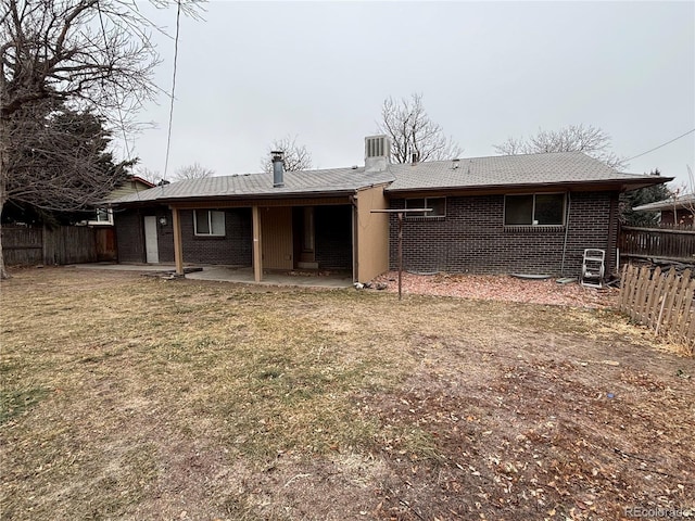 back of property with a lawn, central air condition unit, and a patio