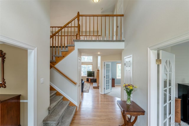 14261 W Evans Cir, Lakewood, CO 80228 - entryway featuring stairs, a towering ceiling, and light wood-type flooring