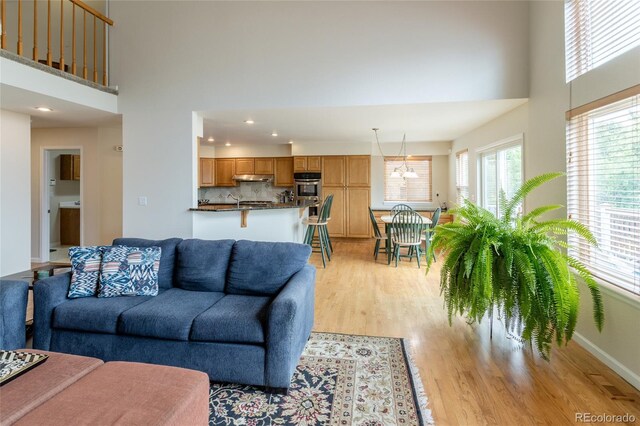 14261 W Evans Cir, Lakewood, CO 80228 - living area with plenty of natural light, a high ceiling, light wood-style flooring, recessed lighting, and a chandelier