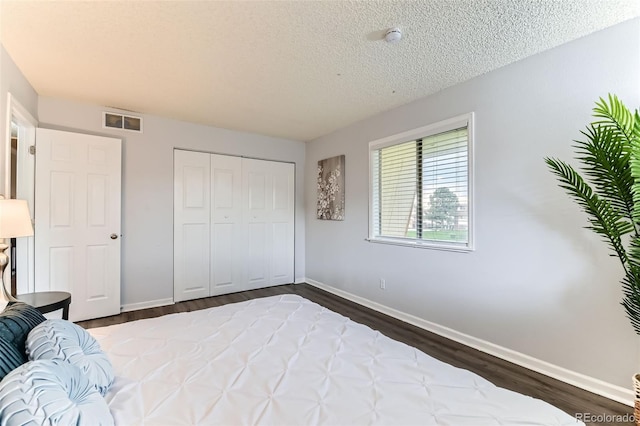 10211 Ura Ln Unit 1-308, Thornton, CO 80260 - bedroom with dark wood-style floors, a textured ceiling, and a closet