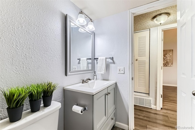 10211 Ura Ln Unit 1-308, Thornton, CO 80260 - bathroom with vanity, a textured wall, and wood finished floors