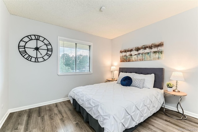10211 Ura Ln Unit 1-308, Thornton, CO 80260 - bedroom featuring wood finished floors and a textured ceiling