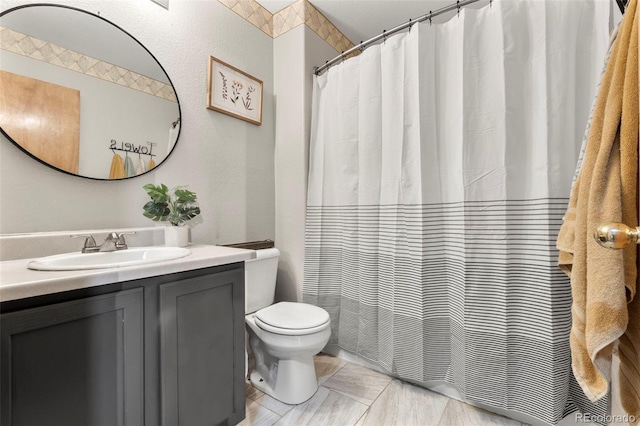 bathroom featuring vanity, a shower with shower curtain, and toilet