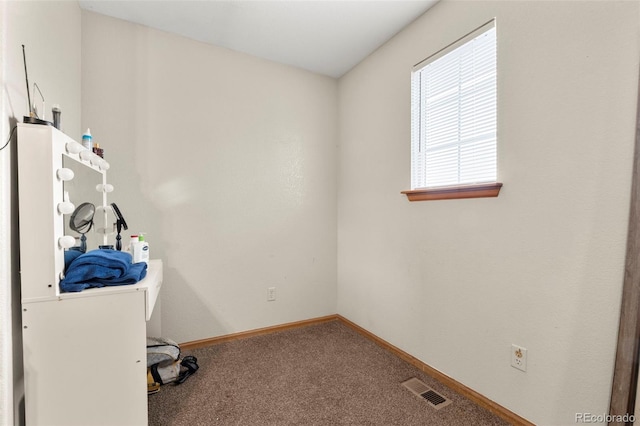 carpeted office space featuring visible vents and baseboards