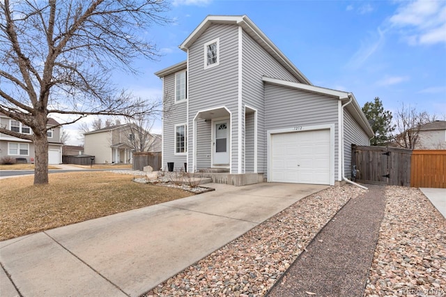 view of front of home featuring concrete driveway, fence, a garage, and a gate