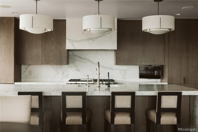 kitchen with pendant lighting and light stone countertops