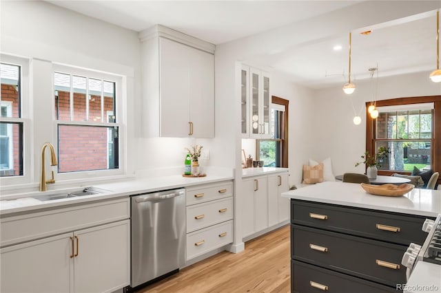 kitchen with a sink, light countertops, white cabinets, and stainless steel dishwasher