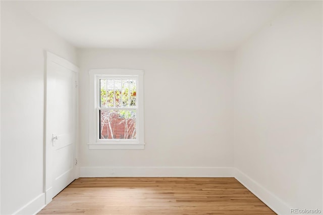 unfurnished room featuring baseboards and light wood-style floors