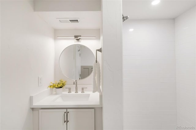 bathroom with vanity, recessed lighting, a shower, and visible vents