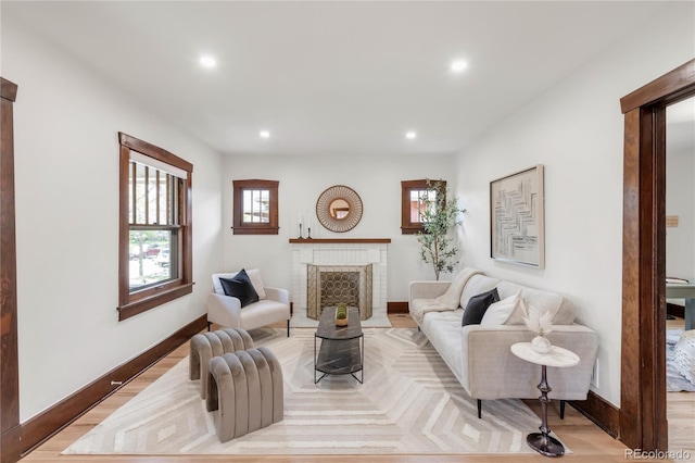 living area featuring recessed lighting, baseboards, light wood-style floors, and a fireplace