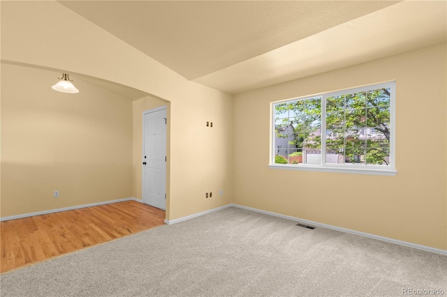 carpeted empty room featuring baseboards