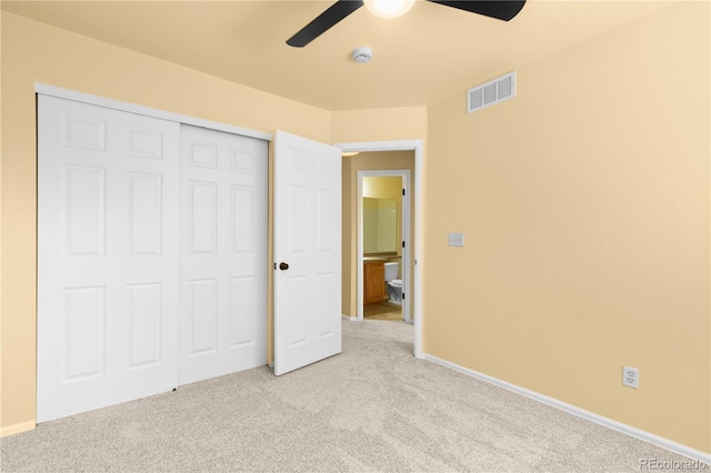 unfurnished bedroom featuring light colored carpet, a closet, a ceiling fan, and baseboards