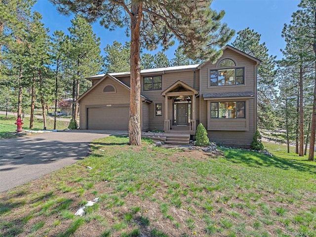 4228 Scenic Village Dr, Evergreen, CO 80439 - traditional home featuring driveway, a garage, and a front lawn