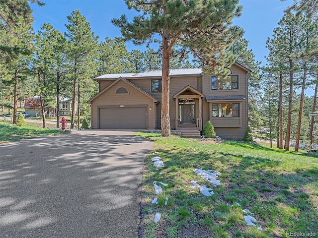 4228 Scenic Village Dr, Evergreen, CO 80439 - view of front facade with asphalt driveway, a garage, and a front yard