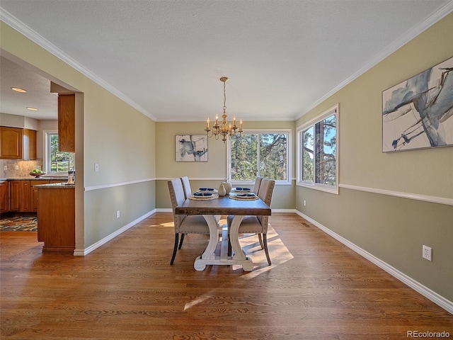 4228 Scenic Village Dr, Evergreen, CO 80439 - dining area with baseboards, a chandelier, dark wood-style floors, and ornamental molding