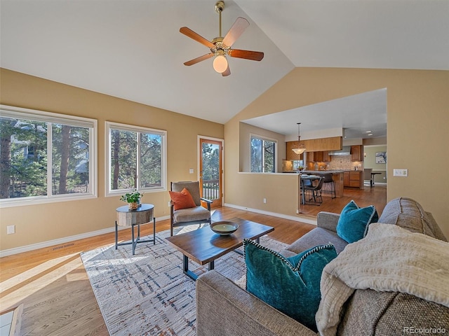 4228 Scenic Village Dr, Evergreen, CO 80439 - living area featuring light wood-style flooring, a ceiling fan, baseboards, and high vaulted ceiling
