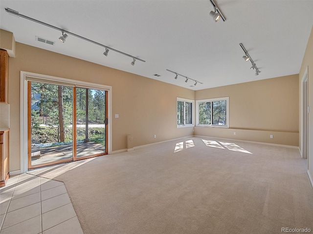 4228 Scenic Village Dr, Evergreen, CO 80439 - unfurnished living room with track lighting, baseboards, light colored carpet, and light tile patterned floors