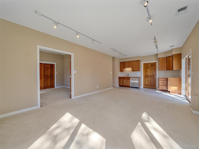 4228 Scenic Village Dr, Evergreen, CO 80439 - unfurnished living room featuring track lighting, light colored carpet, baseboards, and a sink