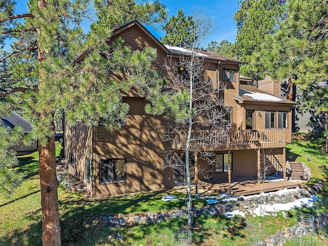 4228 Scenic Village Dr, Evergreen, CO 80439 - rear view of property featuring a wooden deck, a chimney, a patio, and a lawn