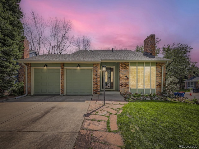 ranch-style home featuring a chimney, a garage, concrete driveway, and brick siding
