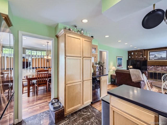kitchen featuring light brown cabinets, dark countertops, recessed lighting, a chandelier, and wood finished floors