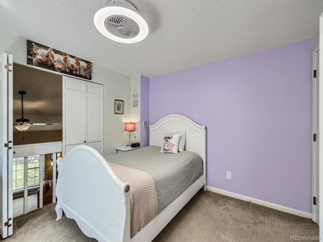 bedroom with carpet flooring, baseboards, a textured ceiling, and a closet