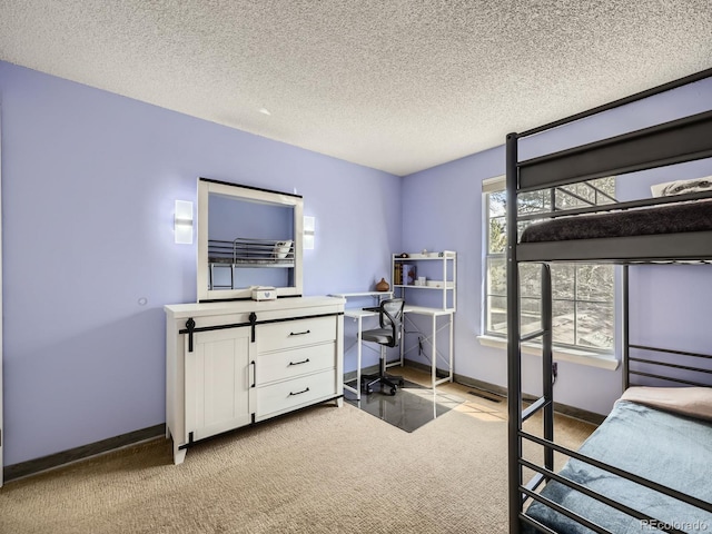bedroom featuring a desk, light carpet, a textured ceiling, and baseboards