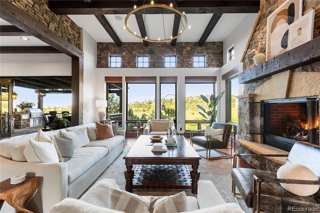 7208 Raphael Ln, Littleton, CO 80125 - living area featuring a towering ceiling, a stone fireplace, beamed ceiling, and a chandelier