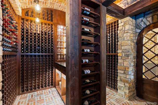 7208 Raphael Ln, Littleton, CO 80125 - wine cellar featuring brick ceiling, lofted ceiling, and brick flooring