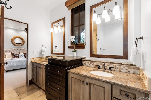 7208 Raphael Ln, Littleton, CO 80125 - bathroom featuring connected bathroom, two vanities, tile patterned floors, ceiling fan, and decorative backsplash