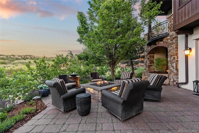 7208 Raphael Ln, Littleton, CO 80125 - patio terrace at dusk featuring a fire pit, a balcony, and a patio area