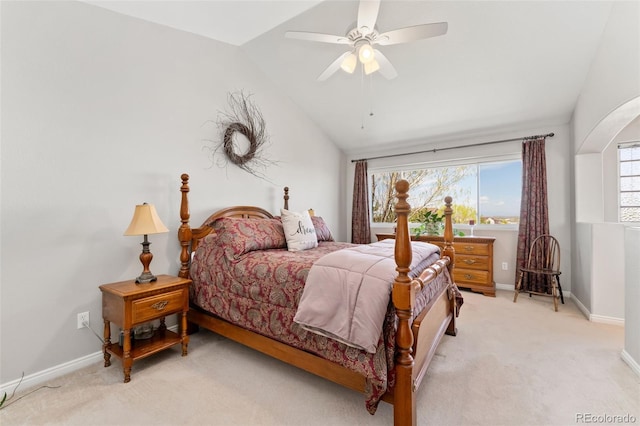 bedroom featuring lofted ceiling, baseboards, light carpet, a ceiling fan, and arched walkways