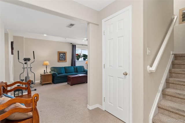 living room featuring light colored carpet, stairs, and baseboards