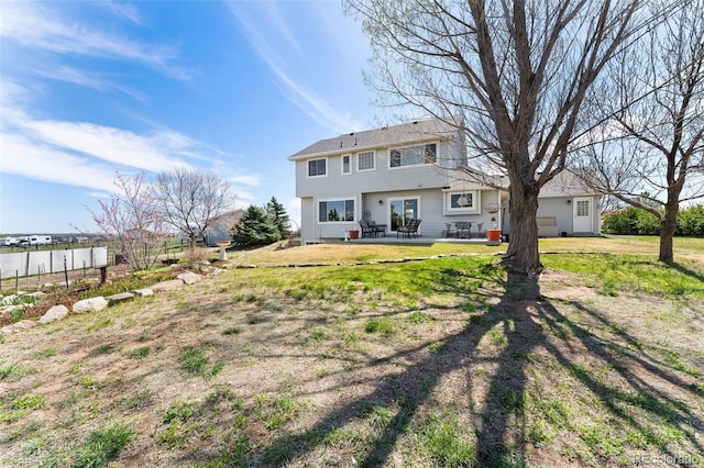 rear view of house with a patio area and a lawn