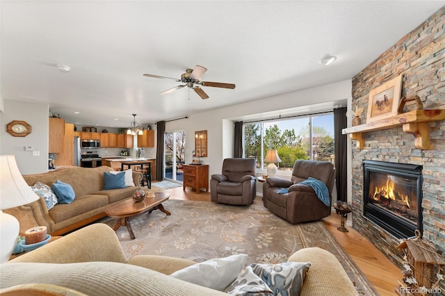 29145 E 160th Ct, Brighton, CO 80603 - living area featuring light wood-style floors, a ceiling fan, and a fireplace