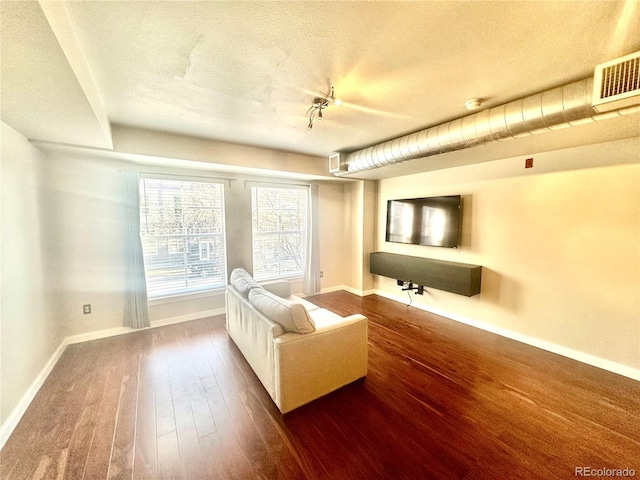 unfurnished room featuring dark wood-type flooring and a textured ceiling