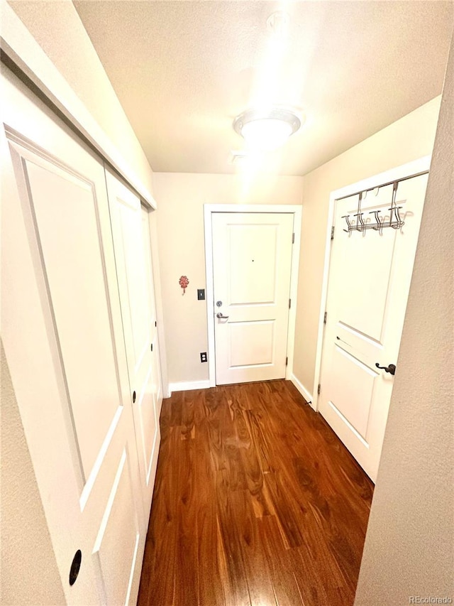 doorway with dark hardwood / wood-style floors and a textured ceiling