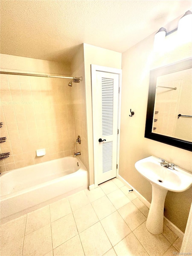 bathroom with tiled shower / bath, tile patterned flooring, and a textured ceiling