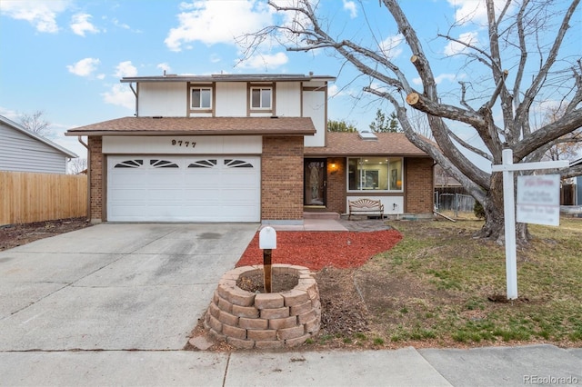 view of front of house with a garage, concrete driveway, brick siding, and fence