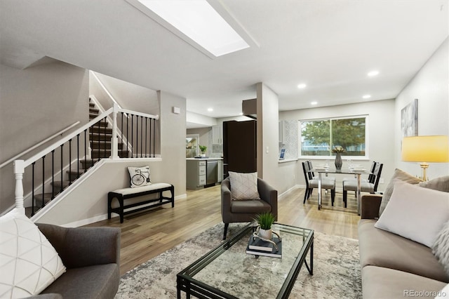 living room with baseboards, stairway, light wood-type flooring, and recessed lighting