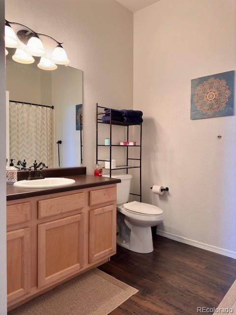 bathroom with vanity, hardwood / wood-style floors, and toilet