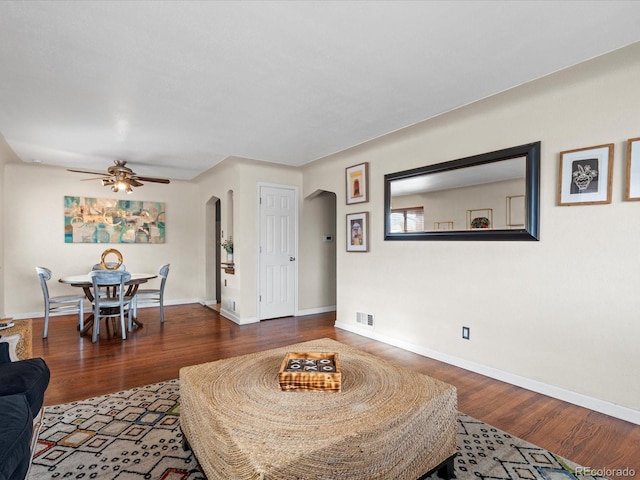 living room with dark hardwood / wood-style floors and ceiling fan