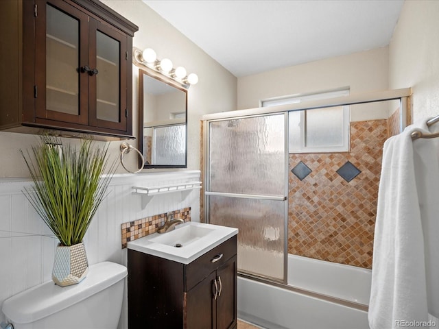 full bathroom with vanity, toilet, shower / bath combination with glass door, and tile walls