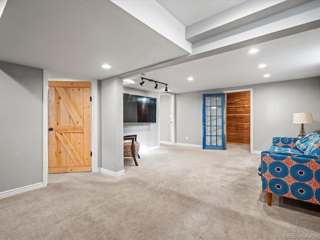 living area with light carpet and track lighting