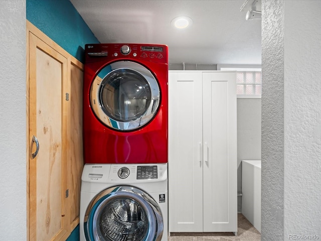 laundry area featuring stacked washing maching and dryer and a textured ceiling