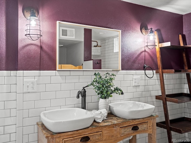 bathroom with vanity and tile walls